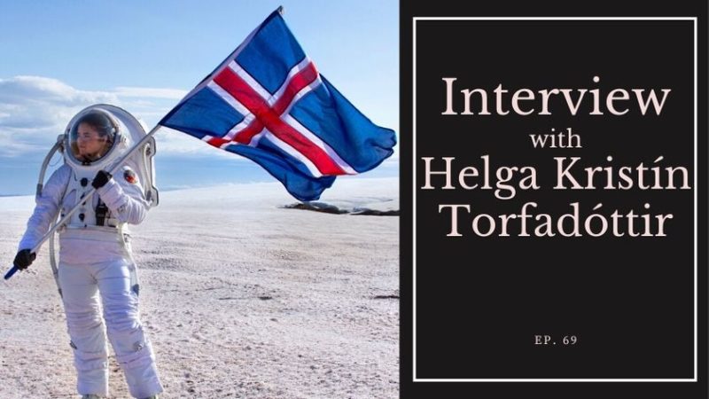 Helga Kristín Torfadóttir, Geology expert, in a space suit in Iceland with the Icelandic flag - Interview with All Things Iceland
